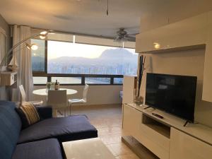 ein Wohnzimmer mit einem Sofa und einem großen TV in der Unterkunft Trisol Seaviews in Benidorm