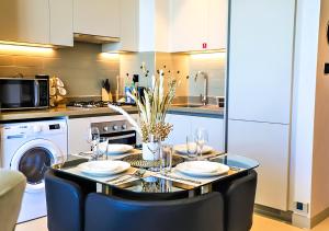 a kitchen with a table with plates and wine glasses at STAY BY LATINEM Luxury 1BR Holiday Home CV A2605 near to Burj Khalifa in Dubai