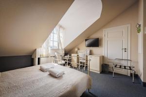 a bedroom with a bed with two towels on it at Moon Garden in Vilnius