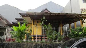 une maison jaune avec une clôture devant elle dans l'établissement VILLA HZ, à Sindanglaya