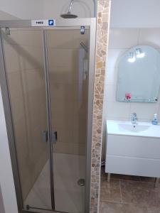 ein Bad mit einer Dusche und einem Waschbecken in der Unterkunft Maison de village confortable entièrement rénovée in Saint-Just