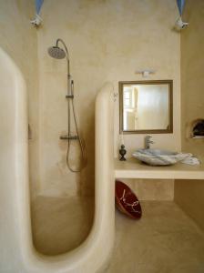 a bathroom with a shower and a sink at Diva Santorini Luxury Villa in Pyrgos