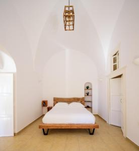 a white bedroom with a bed and a lamp at Diva Santorini Luxury Villa in Pyrgos