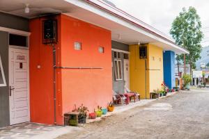 una casa colorida con una puerta naranja en una calle en Penginapan Sulthan Syariah RedPartner, en Takengon