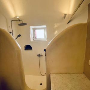 a small bathroom with a shower and a toilet at Diva Santorini Luxury Villa in Pyrgos +10 photos