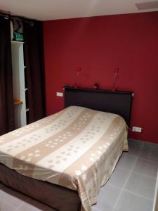 łóżko w pokoju z czerwoną ścianą w obiekcie Chambre d'hôtes Juline w mieście Pouilly-les-Nonains