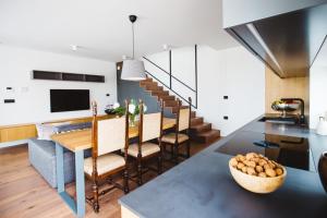 a kitchen and living room with a dining room table and stairs at Villa Kraljica in Portorož