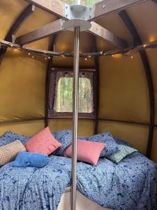 a bed in a small room with pillows on it at Nature calls - tree tent 2 in Būtingė