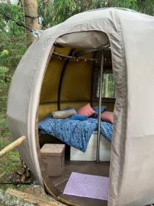 a tent with a bed and pillows in it at Nature calls - tree tent 2 in Būtingė