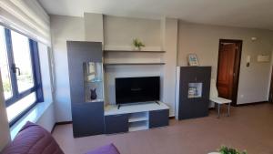 a living room with a flat screen tv in a room at Coira Dream a 100 metros de la playa de Portosín in Portosin