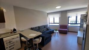 a living room with a blue couch and a table at Coira Dream a 100 metros de la playa de Portosín in Portosin