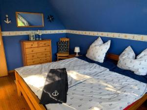 a bedroom with a bed and a blue wall at Das NURDACH Haus in Heiligenhafen