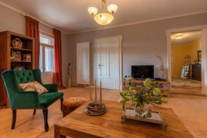 a living room with a green chair and a table at Ferienwohnung Anno1898 Zittau in Zittau