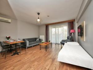 イスタンブールにあるBlueway Hotel Residenceのベッドとリビングルームが備わるホテルルームです。