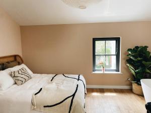 a bedroom with a bed and a window at Luxury bolthole in central St.Agnes with parking. in St. Agnes