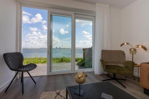 een woonkamer met uitzicht op de oceaan bij Appartement Vista Maris, Havenweg 8-2, Sint Annaland in Sint Annaland