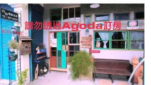 un restaurante con un banco frente a un edificio en 池上5159懷舊民宿 請勿用阿勾達訂房, en Chishang