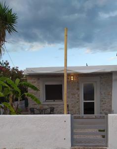 a house with a white fence in front of it at On The Wave in Paralía Iríon