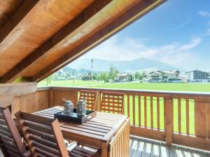 ヴェステンドルフにあるLuxury Apartment in Westendorf near Ski Areaのウッドデッキ(テーブル、椅子付)