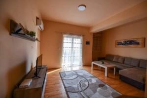 ein Wohnzimmer mit einem Sofa und einem Tisch in der Unterkunft Ohrid Strict Center Apartment in Ohrid