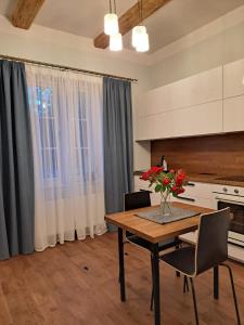 a kitchen with a table with a vase of flowers on it at Tūrisma mītne ZVIEDRI in Līgatne