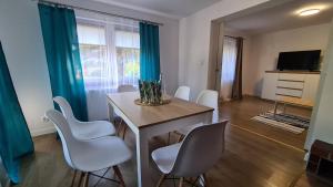 a dining room with a table and white chairs at Domek Zacisze in Laskowa