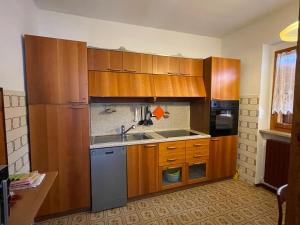 a kitchen with wooden cabinets and a sink at Villetta Casale in Comano Terme +29 photos
