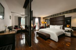 una camera con un grande letto e un divano di La Nueva Boutique Hotel Hanoi & Spa a Hanoi