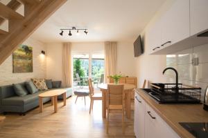 a kitchen and living room with a couch and a table at Beskid Ski Villa in Wisła