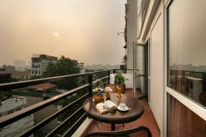 a balcony with a table and a view of the city at La Nueva Boutique Hotel Hanoi & Spa in Hanoi