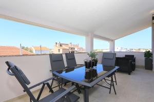 a patio with a table and chairs on a balcony at Luxury Apartment Gašpa with jacuzzi in Privlaka