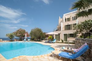 a swimming pool with chairs and a building at Villa Luisa Exclusive Residences in Monemvasia