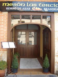 una puerta de entrada de un hotel con dos macetas en Las Tercias, en Simancas