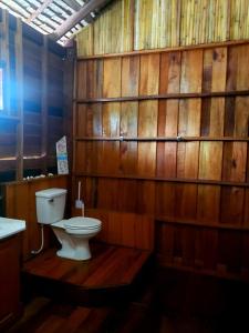 a bathroom with a toilet and a wooden wall at Lipe BeachHouse in Ko Lipe