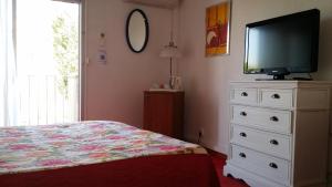 1 dormitorio con cama y vestidor con TV en La Voile D' Or, en Cap d'Agde
