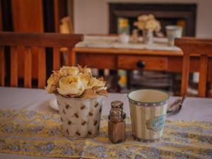 a vase of flowers sitting on a table with a candle at St Phillips Bed & Breakfast in Port Elizabeth