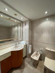 ein Badezimmer mit einem Waschbecken, einem WC und einem Spiegel in der Unterkunft Jardines del Turia in Valencia