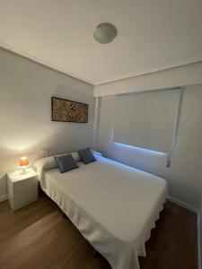 um quarto com uma cama branca e uma janela em Jardines del Turia em Valência