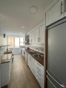 a kitchen with white cabinets and a sink at Jardines del Turia in Valencia