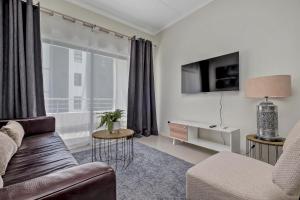 un salon avec un canapé et une grande fenêtre dans l'établissement Smart Apartment, à Midrand