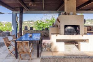 a patio with a table and a pizza oven at Serenity Villa with pool, Kalesa Heraklion in Yiofirákia