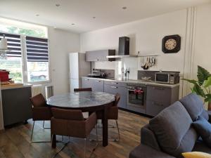 a living room with a table and a kitchen at L'entre deux Eaux 'Maison' Balcon 'et Jardin in Reims