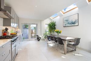 a kitchen with a table and chairs and a dining room at ALTIDO 3-bedroom family home w/ garden in London