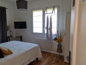 1 Schlafzimmer mit einem weißen Bett und 2 Fenstern in der Unterkunft L'entre deux Eaux 'Maison' Balcon 'et Jardin in Reims