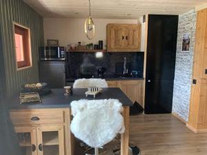 a kitchen with a table with a white chair in it at Fleur et Benj in Aussois