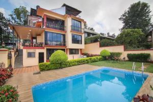 a house with a swimming pool in front of it at Titan villa in Panchgani