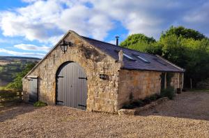 an old stone barn with a white door at Underhill Coach House in Whitby