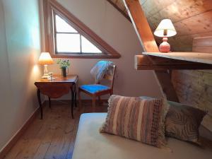 a attic room with a bed and a desk and a window at Kurrebo in Urshult