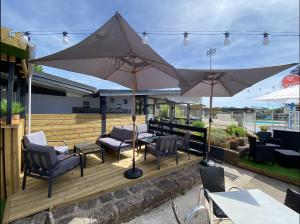 a patio with chairs and umbrellas on a deck at Domaine du Château-Epinal in Épinal