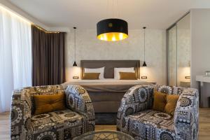 een hotelkamer met een bed en twee stoelen bij Mirabilis Residence II in Zadar